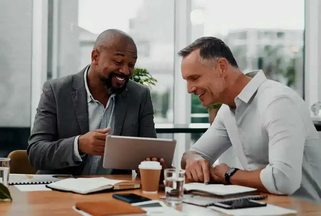 Business professionals discussing ideas with a tablet in a modern office.